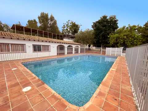 piscina vallada con el edificio principal detrás