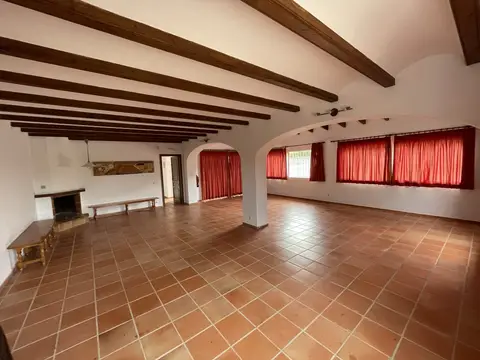 salón amplio con vigas de madera y chimenea