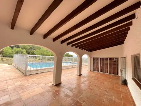 terraza porticada con vistas a la piscina