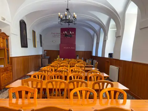 comedor del albergue, con las mesas largas de madera bajo la bóveda