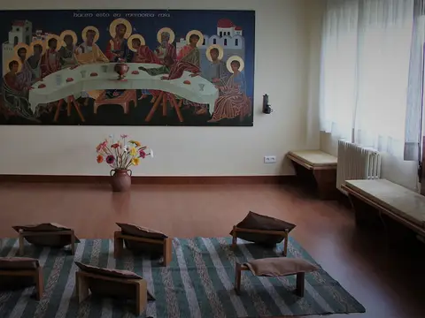 sala de interioridad de la casa, con los bancos bajos y el mural del cenáculo