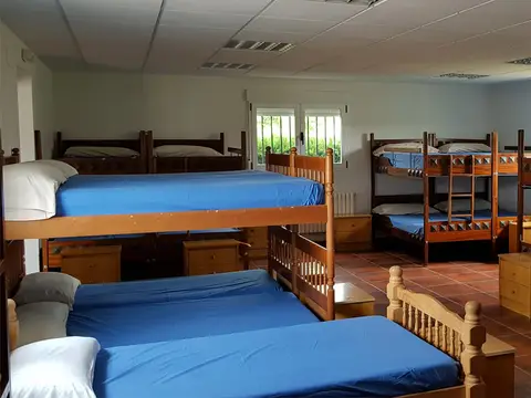 dormitorio de literas del albergue El Castillo, dentro de los jardines de la casa