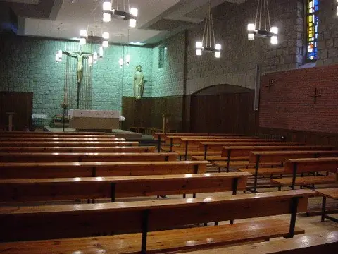 iglesia de la casa de ejercicios, con los bancos de madera y las vidrieras