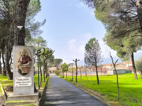 camino de entrada a la finca, con el monolito de la «Colonia Mamá Margarita» de los Salesianos
