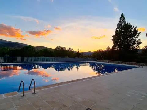 la piscina del centro al atardecer, con la sierra al fondo