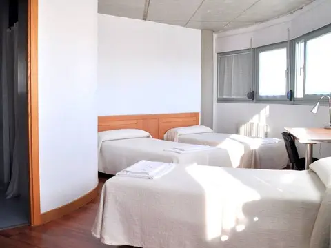 habitación de la residencia del CITeS, con tres camas, mesa de estudio y baño propio