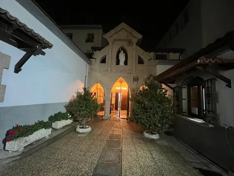 patio de entrada del monasterio de noche, con la portada de piedra y la imagen de la Virgen sobre el arco