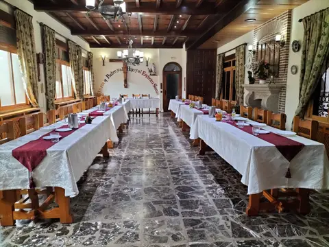 comedor del monasterio con las mesas puestas bajo el techo de vigas de madera