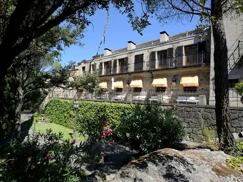 el edificio de La Pililla desde la parte alta de la finca, entre los pinos