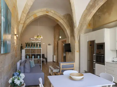 salón y cocina de un apartamento, bajo bóvedas de piedra