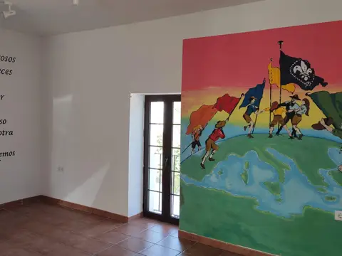sala con el mural scout y la oración pintada en la pared
