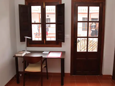 habitacion con escritorio y ventana al balcon
