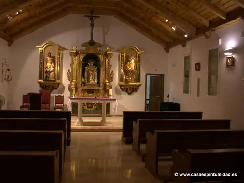 la capilla de la casa con los bancos y el retablo