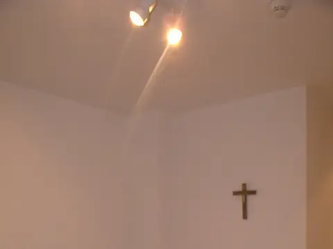 una habitación individual con su crucifijo