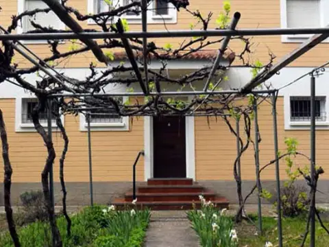 jardín con la pérgola delante de la puerta