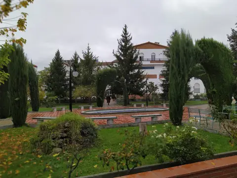 jardín de la casa de espiritualidad con la fachada blanca del edificio