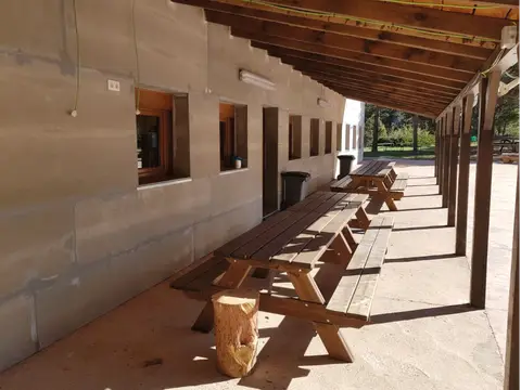 porche del albergue con las mesas de madera