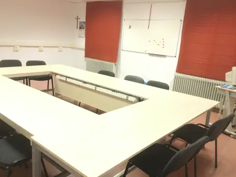 sala de reuniones del albergue con las mesas en U