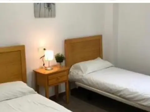 dormitorio con dos camas (recorte del cartel de la diócesis)