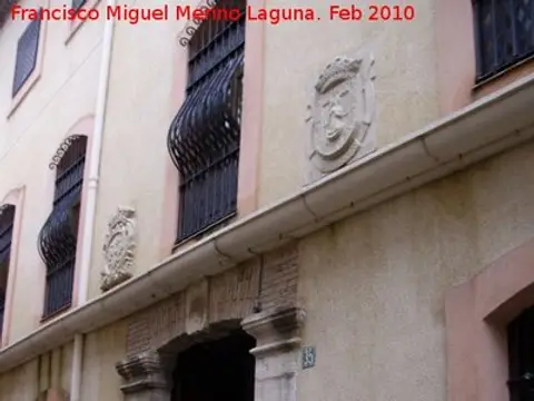 fachada con ventanas enrejadas y relieves de piedra