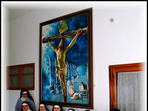 la comunidad de dominicas reunida junto a un cuadro del Cristo del convento