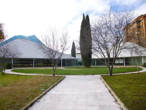 el conjunto parroquial desde el jardín central, con el camino de acceso y los cipreses