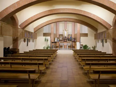 capilla grande de la casa, con la bóveda de ladrillo, los bancos y el altar al fondo