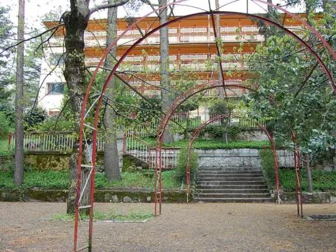 la pérgola metálica del jardín, con la escalinata y el edificio al fondo