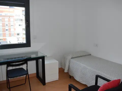 habitación individual con cama, mesa de estudio y ventana