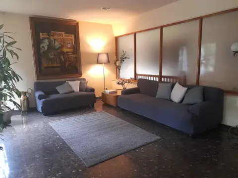sala de estar con sofás y lámpara de pie