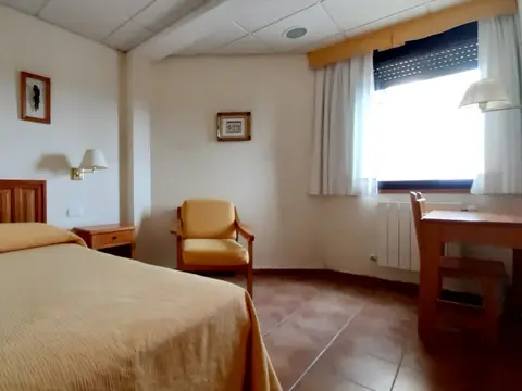 habitación con cama, butaca y mesa de trabajo