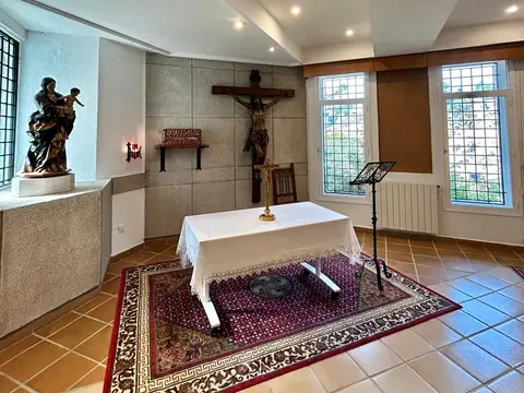 capilla de la casa, con el altar, el crucifijo y las vidrieras
