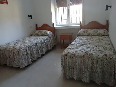 habitación doble con dos camas y ventana al jardín