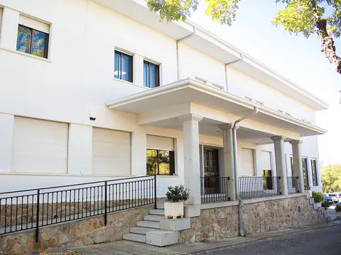 fachada principal de la casa, con el porche de columnas y la escalera de acceso