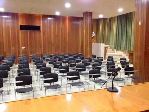 salón de actos con las sillas en filas y el estrado