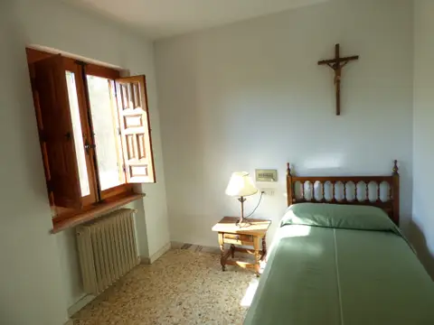 habitación individual con cama, mesilla, escritorio y ventana