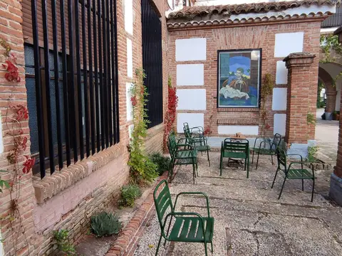 porche exterior con pilares de ladrillo y sillas junto al patio