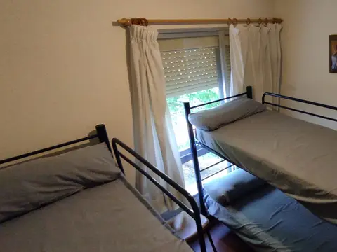 habitación con dos camas y ventana al jardín