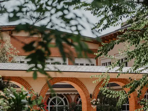 fachada del edificio principal de la casa de espiritualidad, con los soportales de ladrillo