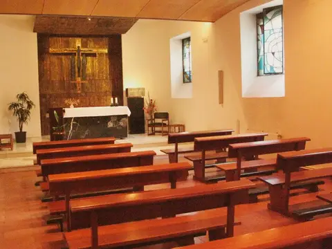capilla de la casa, con los bancos de madera y el altar