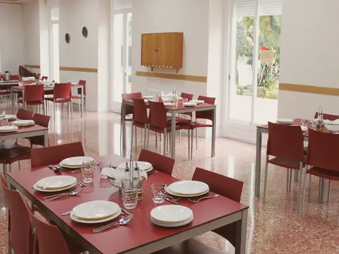 comedor con las mesas puestas y ventanales al jardín