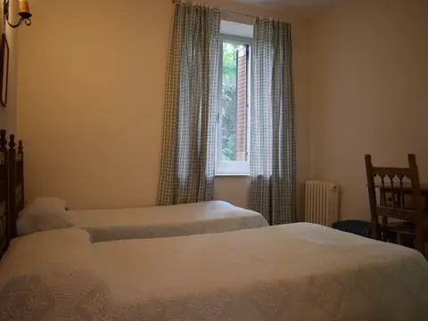 habitación doble con dos camas y ventana al jardín