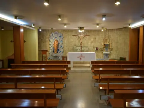 capilla grande de la casa, con los bancos de madera y el altar