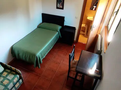 habitación individual con cama, mesa de trabajo y armario