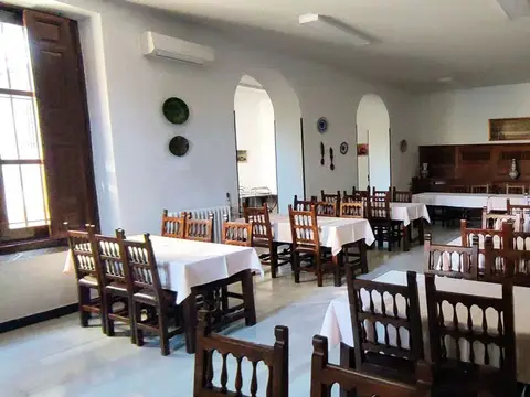 comedor con las mesas alargadas y las sillas de madera