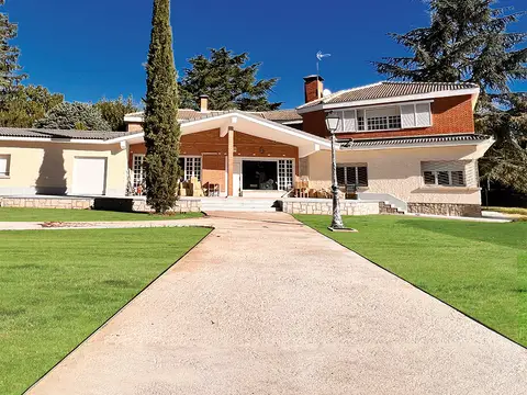 fachada de la casa vista desde el camino de entrada, con el jardín a los lados