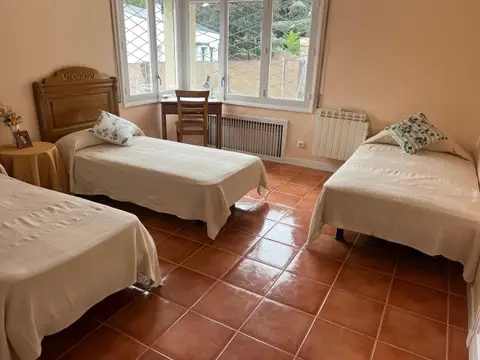 habitación doble con dos camas y ventana al jardín