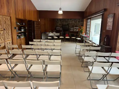 sala grande con las sillas colocadas en filas para una charla o un retiro