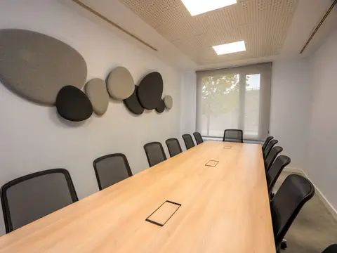sala de juntas con la mesa larga de madera y las sillas de trabajo