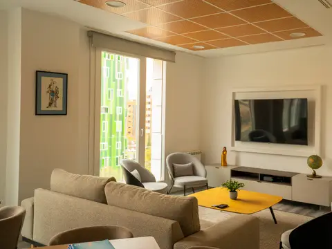 sala de estar con sofás, televisión y salida a la terraza